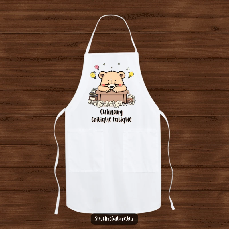 Funny bear desk apron showing a weary animal slumped over a desk surrounded by crumpled ideas, perfect for humorous cooking